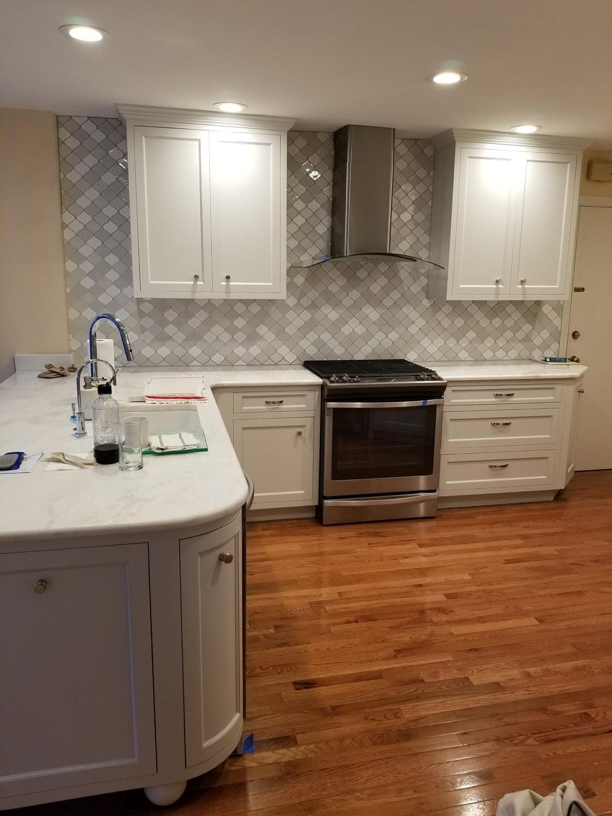 Kitchen with custom cabinetry, tile backsplash and hardwood floors