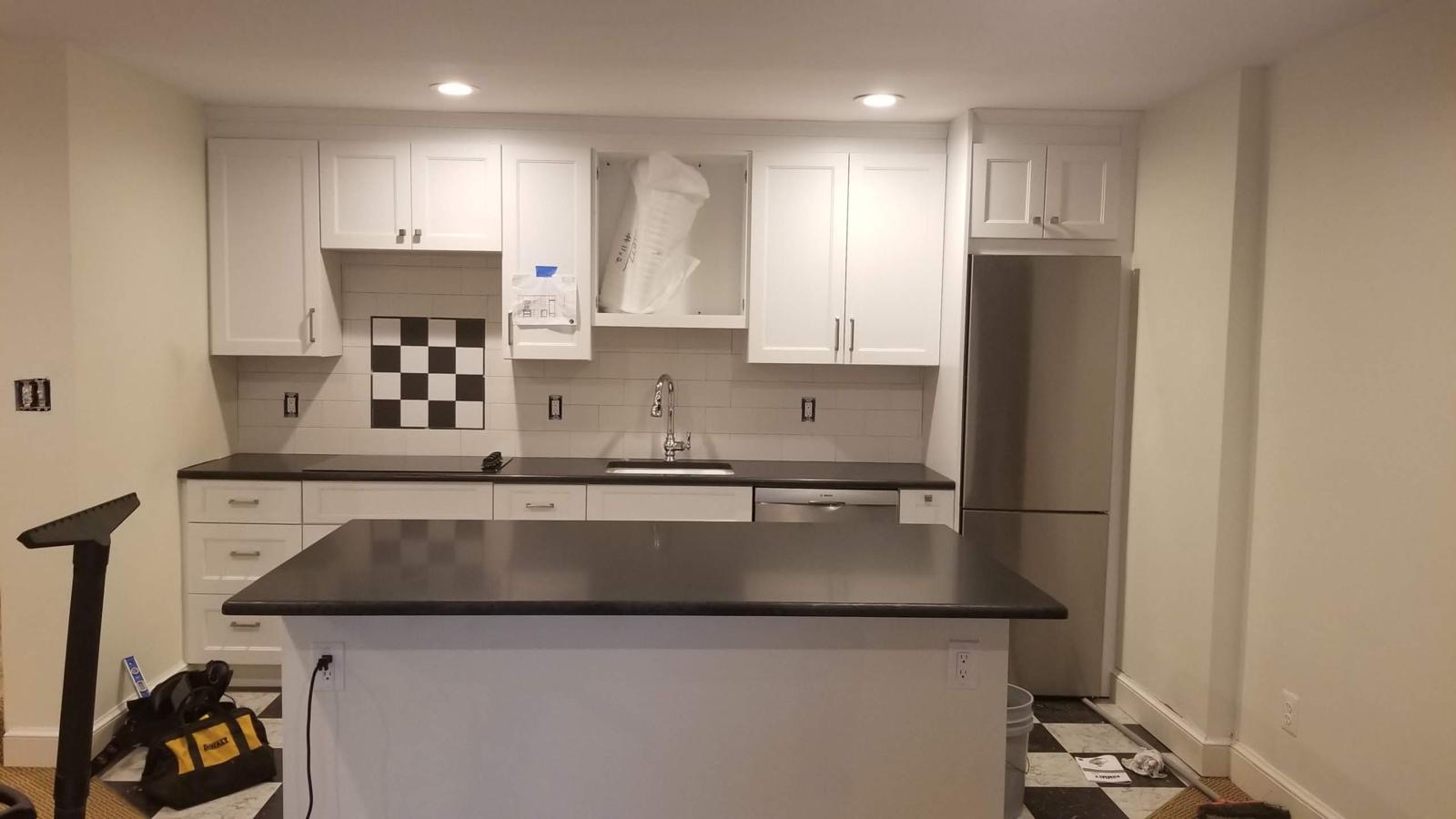Kitchen remodel with white shaker cabinets, dark quartz counters and subway tile backsplash